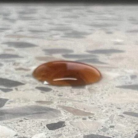 Bestandsfoto: brauner Kaffeetropfen auf einer Terrazzo-Probe zur Einordnung der Steinveredelung in Potsdam